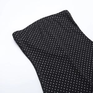 Close-up of black strapless jumpsuit with silver glitter dots and knit texture
