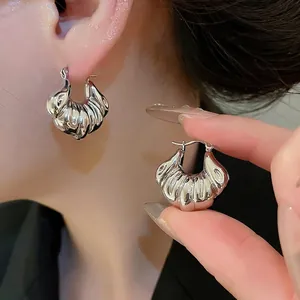 Silver thick pleated hoop earrings with shell texture in a polished metallic finish