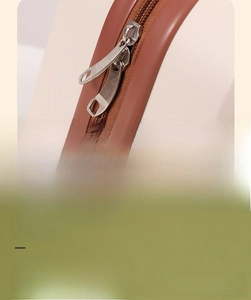 Detailed close-up of smooth silver metal zippers on a macaron mini travel suitcase