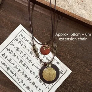 Bohemian beaded wood necklace with spiral metal pendant and golden bow detail
