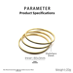 Macro detail of three stacked 3mm gold and black stainless steel circular bangles