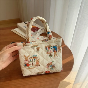 Close-up of quilted cotton phone bag with cute bunny gardening pattern and zipper