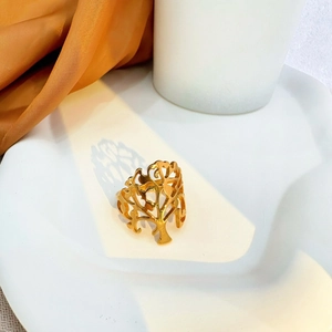 Hollow gold tree pattern open ring in stainless steel displayed on a minimalist white tray