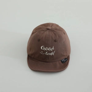 Close-up of brown cotton baby baseball cap with Good Luck embroidery and soft brim detail
