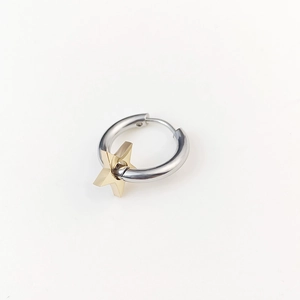 Close-up of minimalist silver hoop earrings featuring a 3D golden star pendant detail