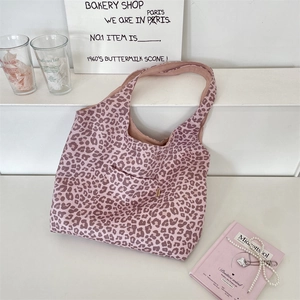 Detailed view of pink leopard print suede tote bag with practical front pocket design