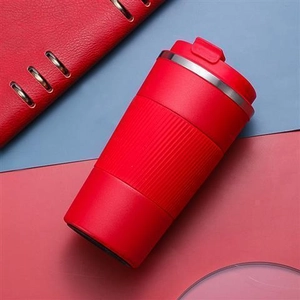 Detail of red stainless steel travel mug with non-slip silicone sleeve and flip-top lid