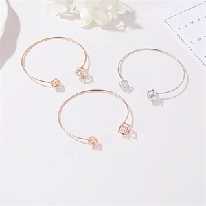 Minimalist open bangles with hollow geometric cubes and zircons in gold and silver