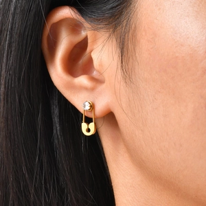 Golden safety pin zircon stud earrings in stainless steel shown on a model's ear