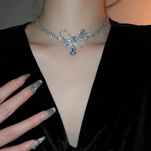 Close-up of silver bow and teardrop pendant necklace set with shimmering zircons