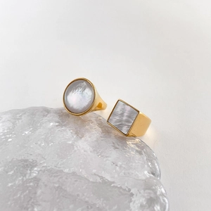 Close-up of geometric gold rings featuring natural mother of pearl shell inlays