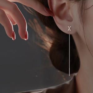 Minimalist silver chain earrings with X letter pendant worn for elegant dangle style