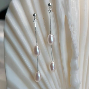 Elegant S925 silver long tassel earrings with freshwater rice pearls on a white seashell