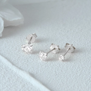 Macro detail of S925 sterling silver stud earrings with heart and round zircon stones