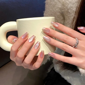 Pink aurora coffin press-on nails with white 3D butterfly art on a ceramic cup