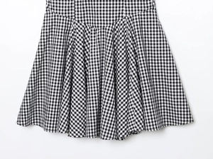 Detailed close-up of classic black and white gingham fabric with elegant pleated folds