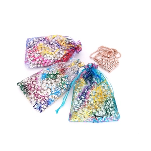 Close-up of heart-shaped necklace and colorful coral pattern organza gift bags