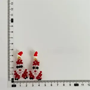 Detailed view of handmade beaded Santa Claus earrings with size scale measurement