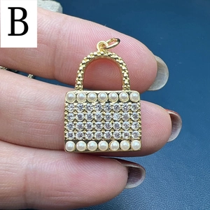 Macro shot of a gold-plated handbag-shaped pendant with rows of cubic zirconia and pearls