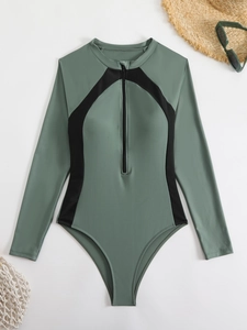 Détail d'un maillot de surf à manches longues vert sauge avec empiècements noirs et zip