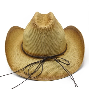 Detailed view of hand-woven natural straw western cowboy hat with brown string bow decoration