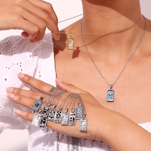 Detail of 18K gold plated tarot card pendant necklace with embossed moon and star motifs