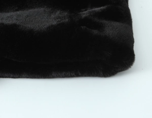 Vue détaillée de la texture de fourrure synthétique noire aux fibres denses et brillantes