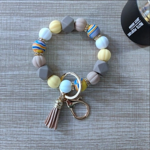 Detail view of silicone bead keychain with pumpkin-shaped beads and a leather tassel