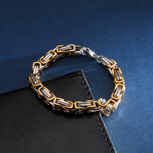 Macro detail of bicolored Byzantine chain bracelet with lobster clasp on leather