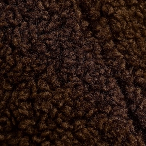 Gros plan sur la texture en fausse fourrure marron foncé montrant des fibres douces