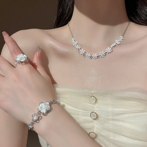 Close-up of floral jewelry set with white pearls and tassels on an elegant female model