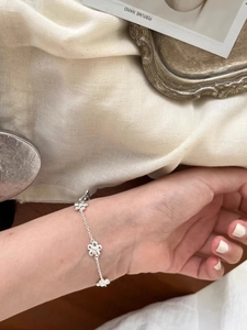 Detailed view of silver flower bracelet on wrist with adjustable chain extension
