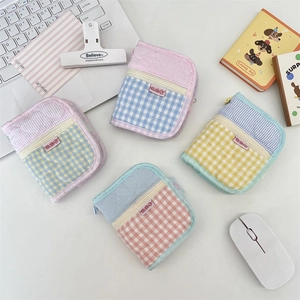 Quilted fabric coin purses in various colors arranged on a desk with a laptop
