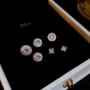 Macro shot of three pairs of silver-plated stud earrings with sparkling zircon stones