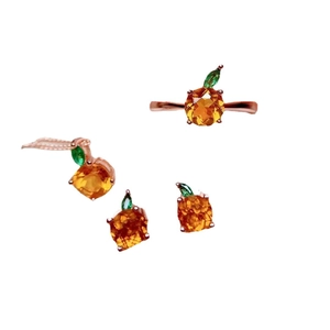 Chic apple-shaped jewelry set with orange gems, green leaves, and rose gold finish