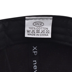 Détail de l'étiquette de lavage interne et des coutures 100% coton sur la casquette noire