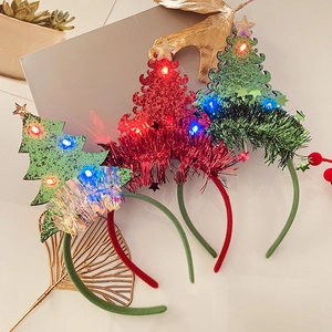 Detail of festive LED Christmas tree headbands with glowing red and green light-up beads