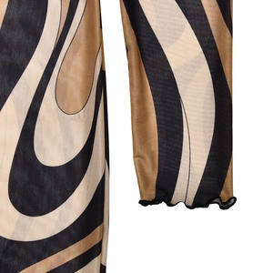 Detail of mesh dress sleeve featuring wavy patterns and ruffled lettuce edge cuff
