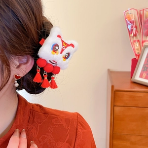 Detailed side view of Chinese New Year lion dance hair clip with red tassels and pom-poms