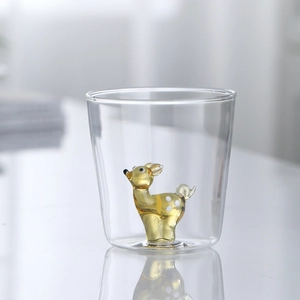 Cute transparent borosilicate glass cup featuring a miniature yellow deer figure inside
