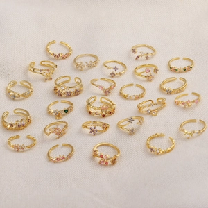 Vue à plat de bagues ajustables dorées avec motifs papillon et fleur serties de zircons