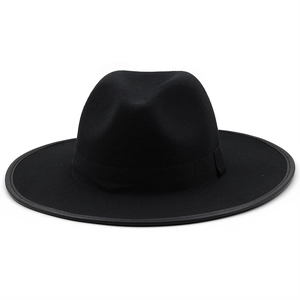 Close-up of black wide brim fedora hat with bound edge and ribbon trim on white background