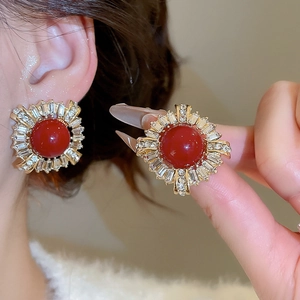 Detailed close-up of retro red zircon earrings with gold plating and sunflower pattern