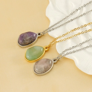 Detail of natural teardrop stone pendants in purple, green and pink on gold chains