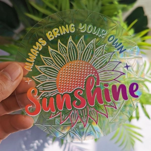 Macro shot of a sunflower holographic window sticker reflecting rainbow light outdoors