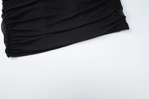 Close-up detail of the black mesh fabric with elegant ruched and pleated design