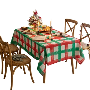 Red and green Christmas plaid tablecloth with festive holiday decor on a dining table