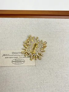 Detail of gold irregular sunburst brooch with inlaid rhinestones and white pearls