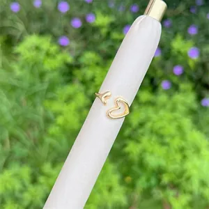 Polished 18K gold-plated open heart ring with hollow design on a white display stand