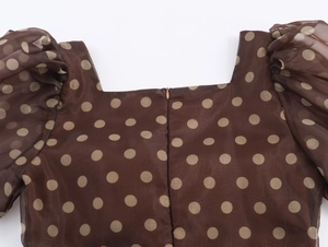 Detail of square neckline and puff sleeves on a brown polka dot organza midi dress